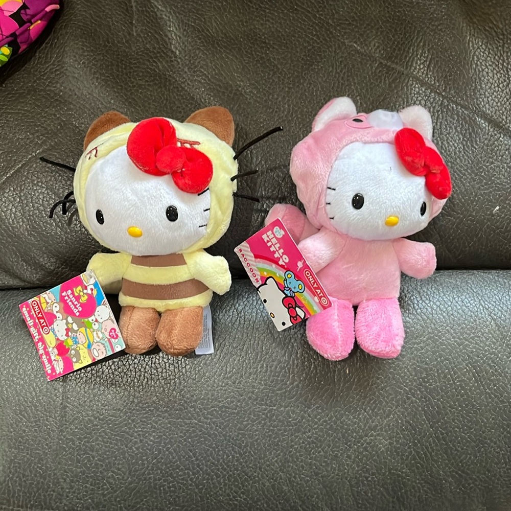 Two hello kitty stuffed animals in animal suits